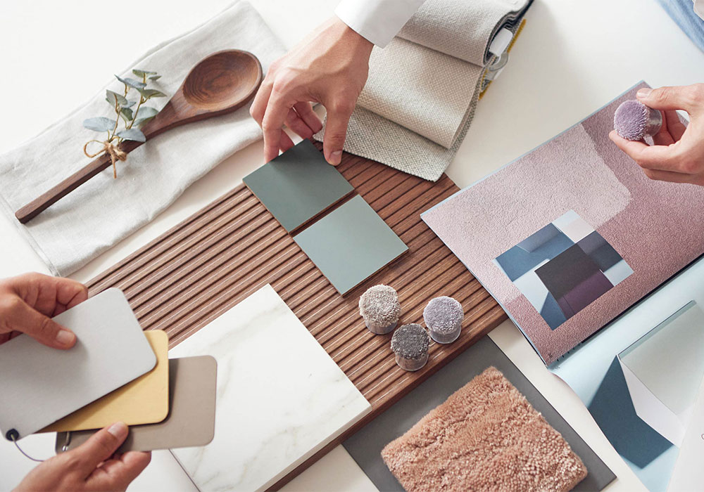 Geschäftsführer David Grüner im Beratungsgespräch. Eine Materialcollage macht Stilrichtungen und Farbharmonien spürbar. 